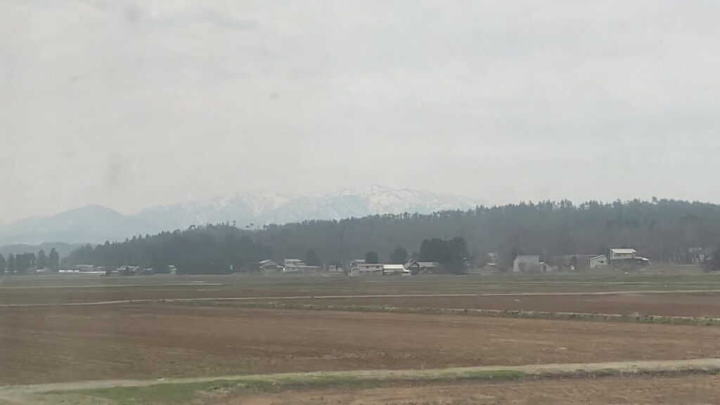 田園風景と背後にそびえる飯豊山地